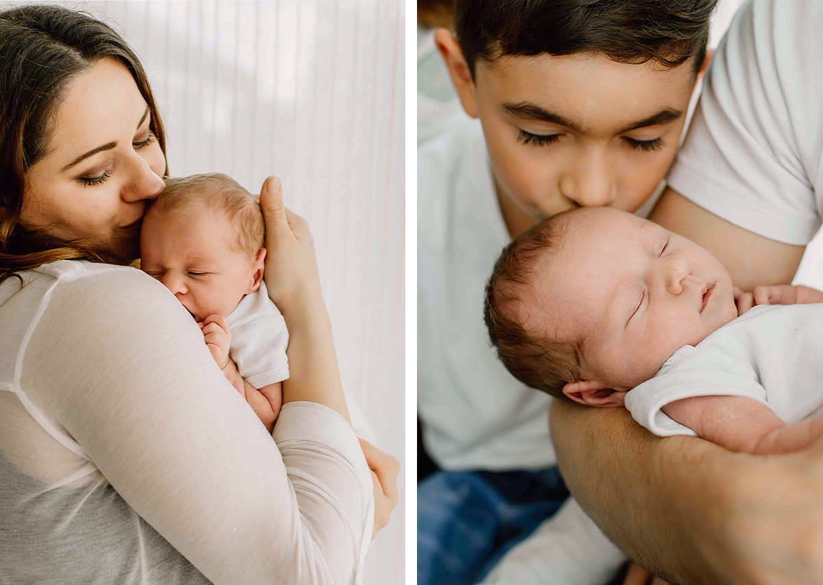 Newbornshooting zu Hause in Pinneberg – Mama hält ihr Baby‑Mädchen, während der große Bruder liebevoll zuschaut