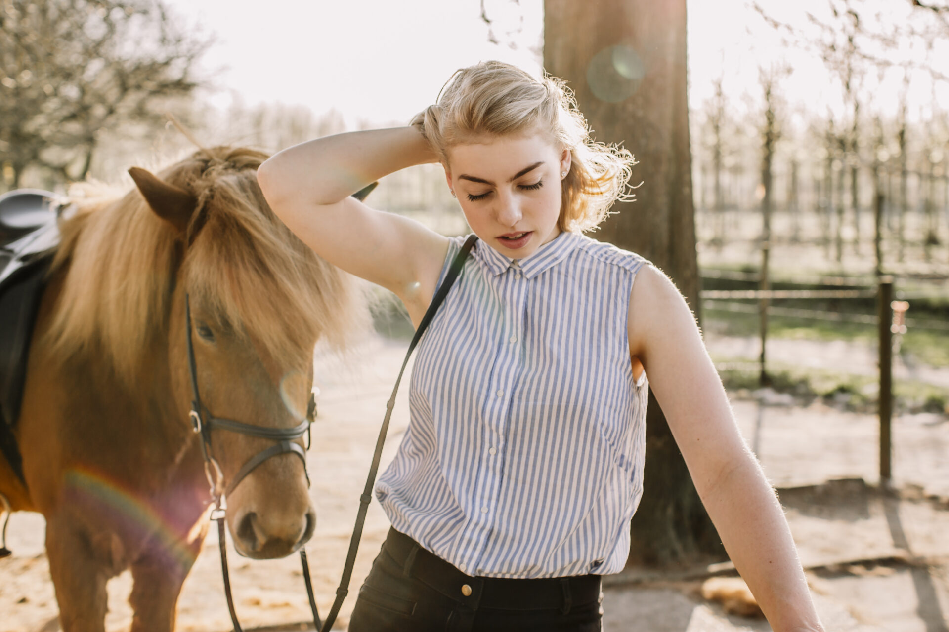 Mädchen steht mit ihrem Pferd im Stall in Wedel, natürliches Portraitshooting